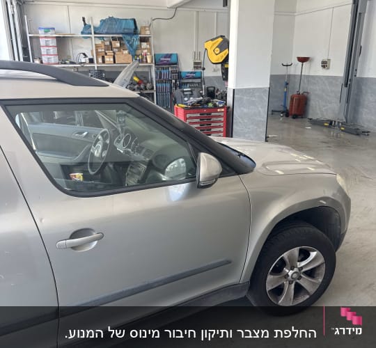 רכב בתוך מוסך עם כלי עבודה וציוד